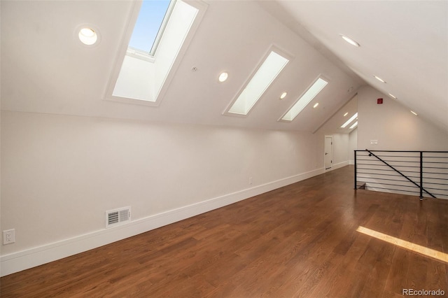 additional living space with dark hardwood / wood-style floors and lofted ceiling with skylight