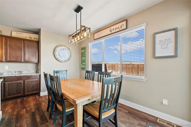 dining area with a notable chandelier, dark wood finished floors, visible vents, and baseboards