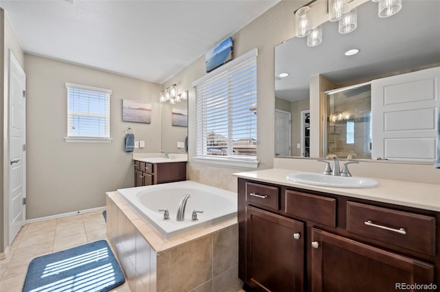 bathroom featuring a garden tub, two vanities, a stall shower, a sink, and tile patterned floors