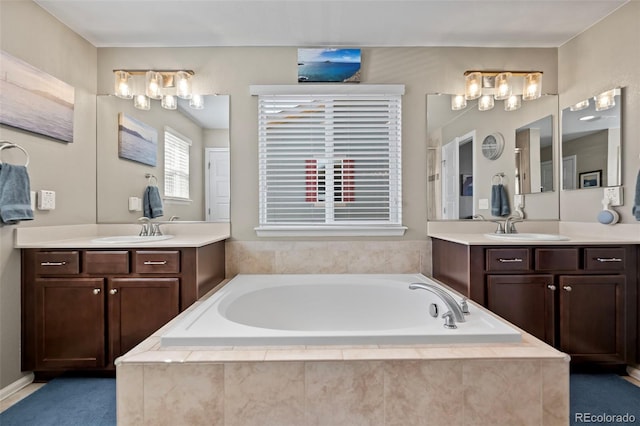 full bathroom with a garden tub, two vanities, and a sink