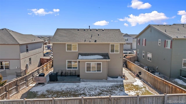 back of property featuring a fenced backyard, a patio, and roof with shingles