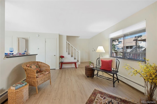 living area with light hardwood / wood-style floors and baseboard heating