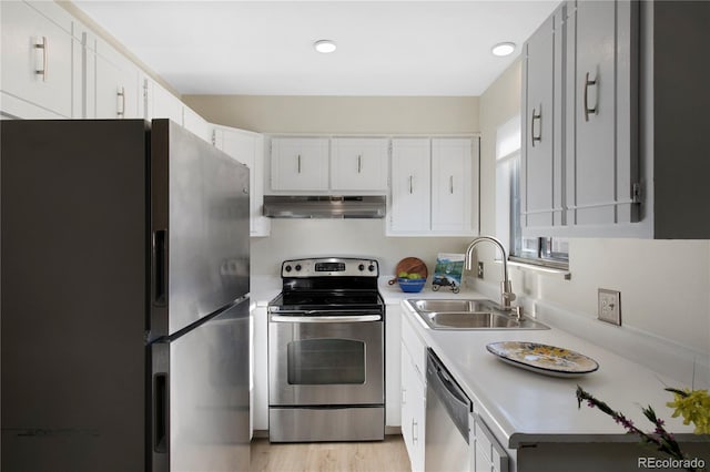 kitchen with stainless steel appliances, light hardwood / wood-style flooring, white cabinetry, and sink