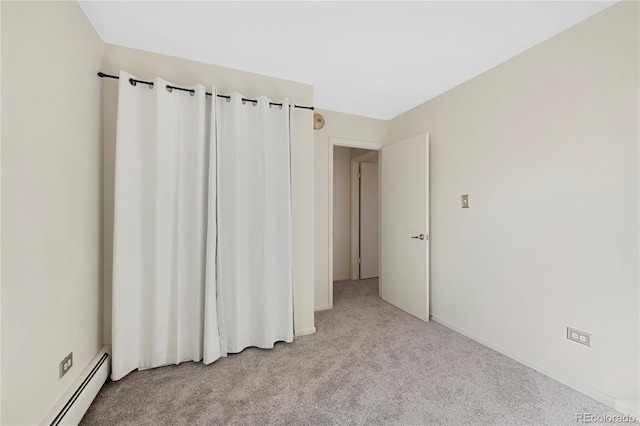 empty room with light colored carpet and a baseboard radiator