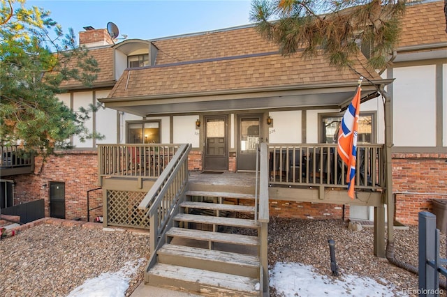 snow covered property entrance featuring covered porch