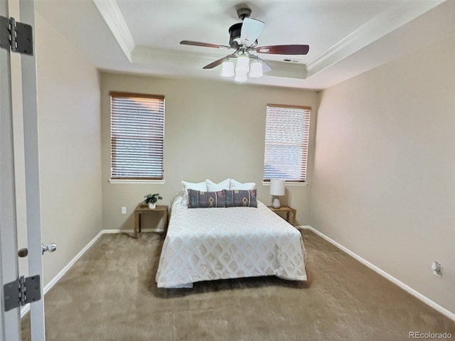 bedroom with a tray ceiling, carpet, and crown molding