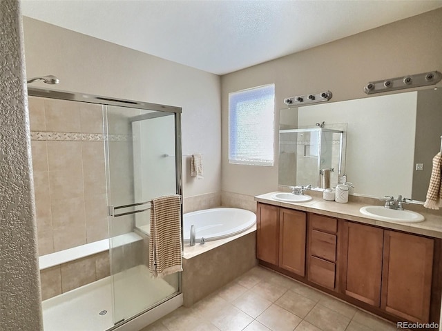 bathroom with a garden tub, tile patterned flooring, a sink, and a stall shower