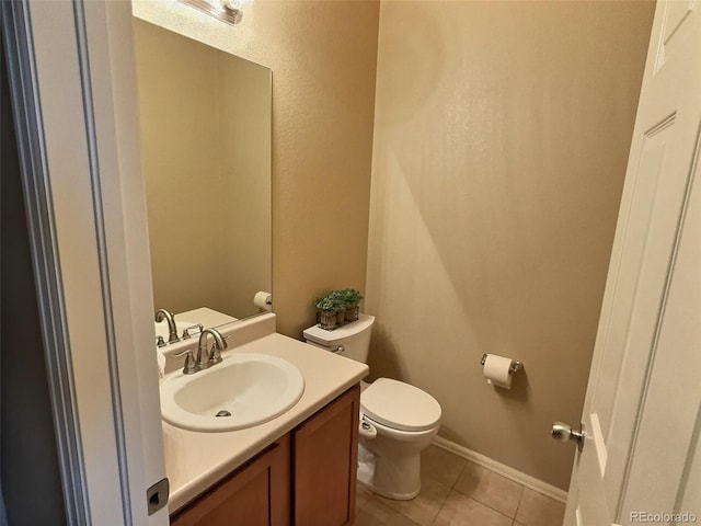 bathroom featuring tile patterned flooring, baseboards, vanity, and toilet