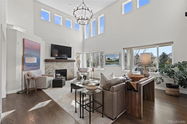 5322 Devils Head Cir, Golden, CO 80403 - living room with plenty of natural light, a chandelier, a stone fireplace, a towering ceiling, and wood finished floors