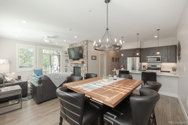 400 Baker Dr Unit Te103, Winter Park, CO 80482 - dining area with light wood finished floors, a fireplace, a chandelier, a ceiling fan, and recessed lighting