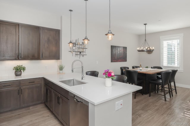 400 Baker Dr Unit Te103, Winter Park, CO 80482 - kitchen with dishwasher, a peninsula, light wood-type flooring, backsplash, and light countertops