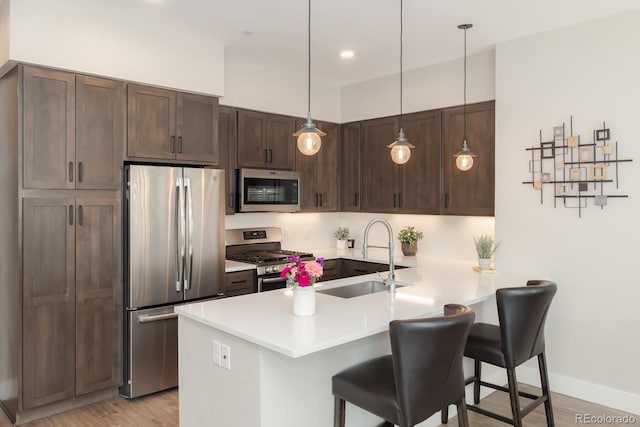 400 Baker Dr Unit Te103, Winter Park, CO 80482 - kitchen featuring stainless steel appliances, a peninsula, a breakfast bar, tasteful backsplash, and dark brown cabinets
