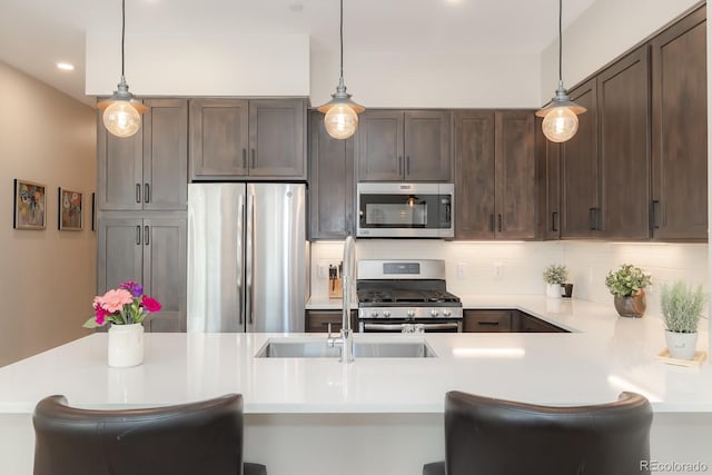 400 Baker Dr Unit Te103, Winter Park, CO 80482 - kitchen featuring stainless steel appliances, light countertops, dark brown cabinets, tasteful backsplash, and decorative light fixtures