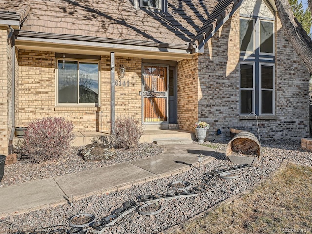 entrance to property featuring brick siding