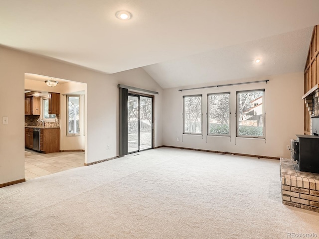 unfurnished living room featuring light colored carpet, sink, and vaulted ceiling