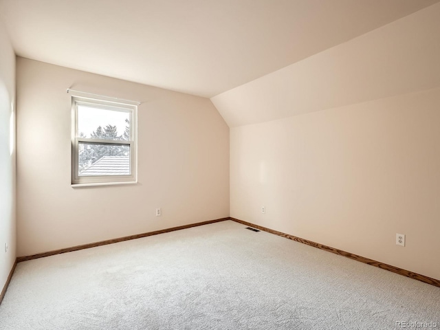 additional living space featuring carpet floors and vaulted ceiling