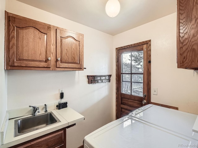 washroom with sink, cabinets, and independent washer and dryer