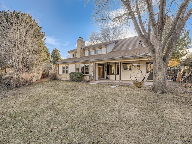 back of property featuring a lawn and a patio