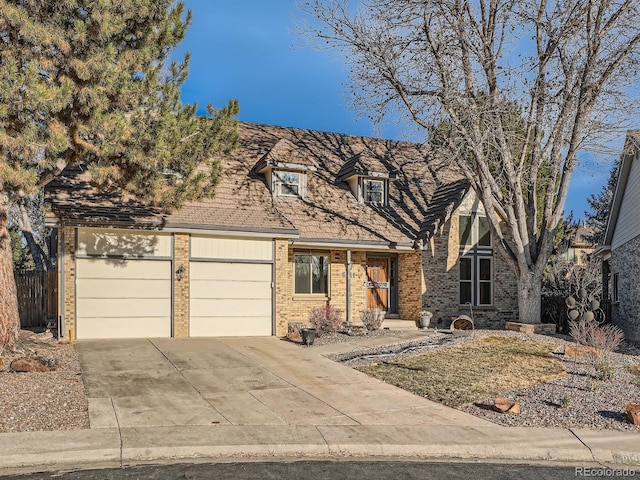 view of front of house featuring brick siding, a garage, concrete driveway, and fence