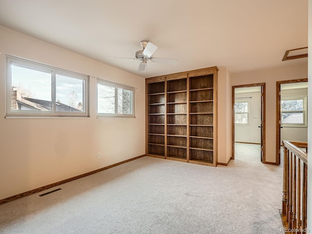 empty room with baseboards, light carpet, and a ceiling fan