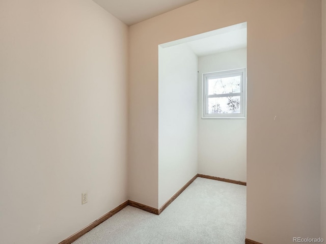 empty room with light colored carpet and baseboards