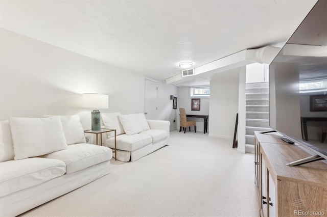 living room featuring visible vents, stairway, and carpet floors
