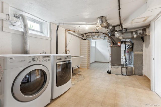 laundry area featuring independent washer and dryer, laundry area, and heating unit
