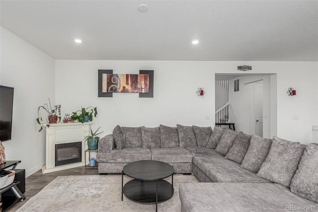 17471 Gandy Dancer Ln, Parker, CO 80134 - living room featuring dark wood-style flooring, stairway, recessed lighting, and a glass covered fireplace