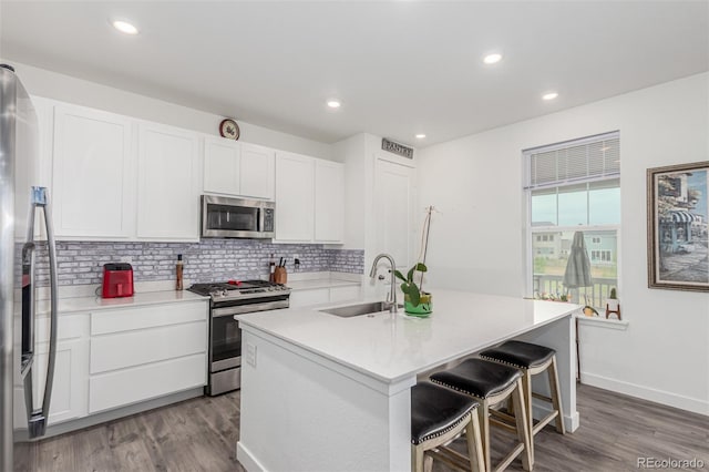 17471 Gandy Dancer Ln, Parker, CO 80134 - kitchen with appliances with stainless steel finishes, dark wood-style floors, decorative backsplash, white cabinets, and recessed lighting
