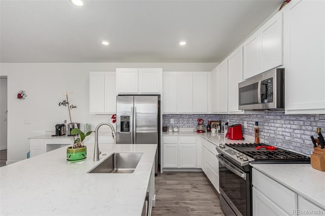 17471 Gandy Dancer Ln, Parker, CO 80134 - kitchen featuring appliances with stainless steel finishes, light wood-style floors, white cabinetry, light stone counters, and recessed lighting