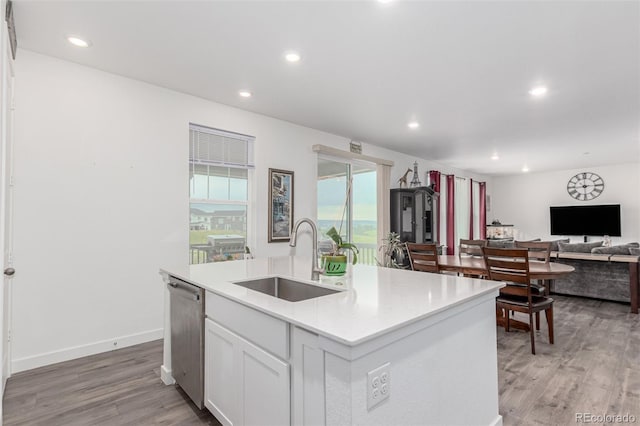 17471 Gandy Dancer Ln, Parker, CO 80134 - kitchen with dishwasher, an island with sink, white cabinets, light wood finished floors, and recessed lighting