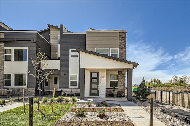 6864 Bryant Ct, Denver, CO 80221 - view of front of property featuring stone siding, an outdoor living space, and a porch