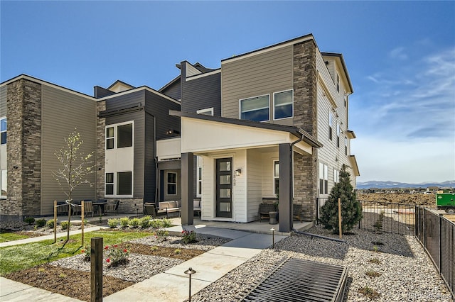 6864 Bryant Ct, Denver, CO 80221 - view of front of home featuring stone siding, a patio, and a mountain view