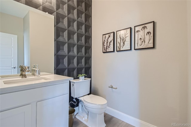 6864 Bryant Ct, Denver, CO 80221 - bathroom featuring vanity, toilet, wood finished floors, and baseboards