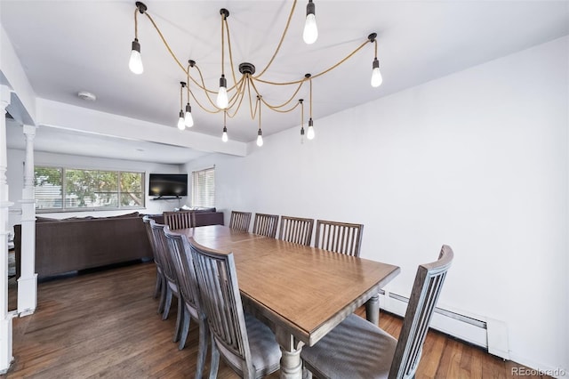 dining room featuring dark hardwood / wood-style flooring, decorative columns, and a baseboard heating unit