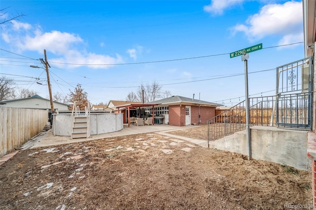 rear view of house featuring a pool and a patio area