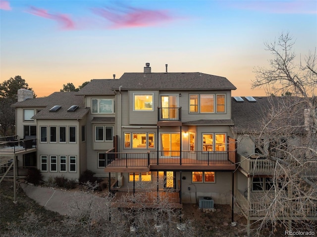 2854 Tenderfoot Hill St, Colorado Springs, CO 80906 - back of property at dusk with a balcony, central air condition unit, a chimney, and a shingled roof