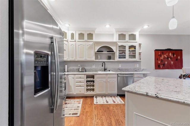 2854 Tenderfoot Hill St, Colorado Springs, CO 80906 - kitchen featuring crown molding, glass insert cabinets, light wood-type flooring, a sink, and stainless steel appliances