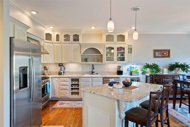 2854 Tenderfoot Hill St, Colorado Springs, CO 80906 - kitchen featuring stainless steel appliances, ornamental molding, a center island, glass insert cabinets, and hanging light fixtures