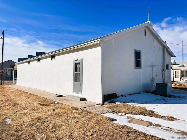 rear view of property featuring stucco siding