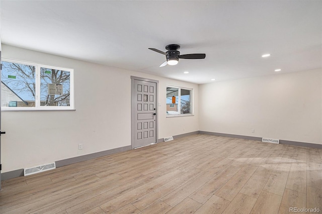 empty room with light hardwood / wood-style flooring, ceiling fan, and plenty of natural light