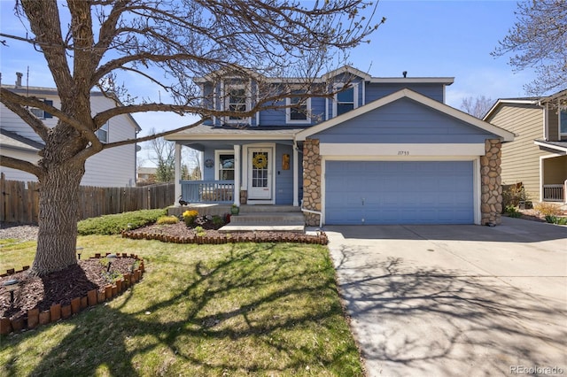traditional-style home featuring driveway, an attached garage, a porch, and stone siding