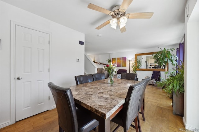 dining space featuring light wood-style flooring and a ceiling fan