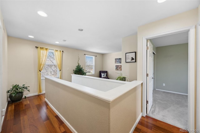 corridor featuring wood finished floors, baseboards, and recessed lighting