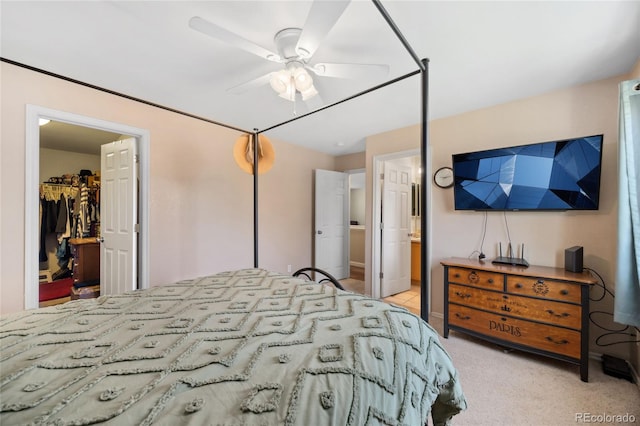 bedroom featuring a walk in closet, a closet, ensuite bathroom, a ceiling fan, and carpet