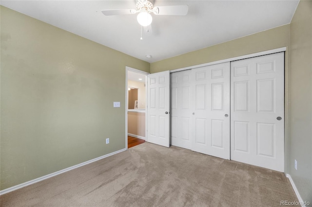 unfurnished bedroom with carpet flooring, baseboards, a closet, and ceiling fan