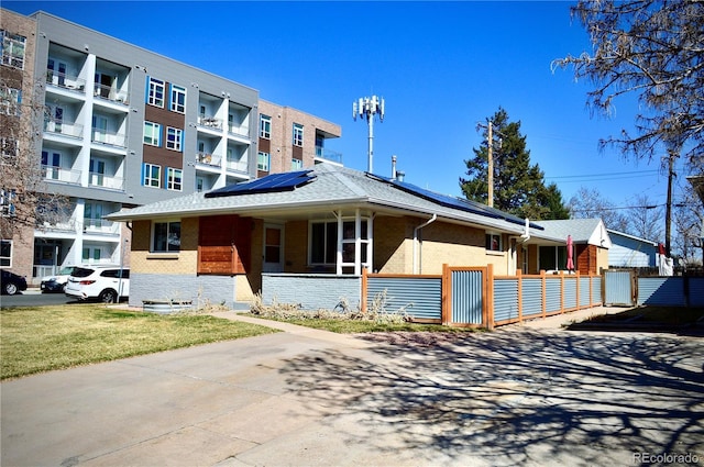 2200 S Cherry St Unit 2216, Denver, CO 80222 - view of front of property with brick siding, roof mounted solar panels, a gate, and a porch