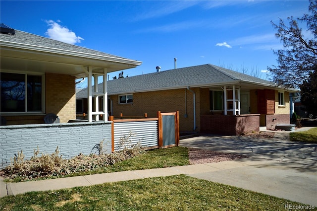 2200 S Cherry St Unit 2216, Denver, CO 80222 - view of side of home with brick siding, covered porch, and roof with shingles