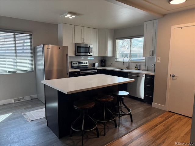 2200 S Cherry St Unit 2216, Denver, CO 80222 - kitchen featuring stainless steel appliances, a sink, a breakfast bar, light countertops, and a kitchen island