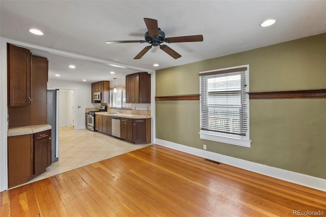 702 E Platte Ave, Colorado Springs, CO 80903 - kitchen with stainless steel appliances, a sink, light countertops, ceiling fan, and baseboards